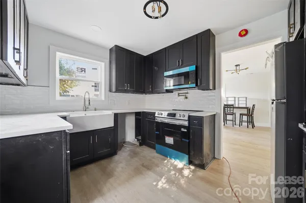 a kitchen with kitchen island granite countertop a stove top oven microwave and refrigerator
