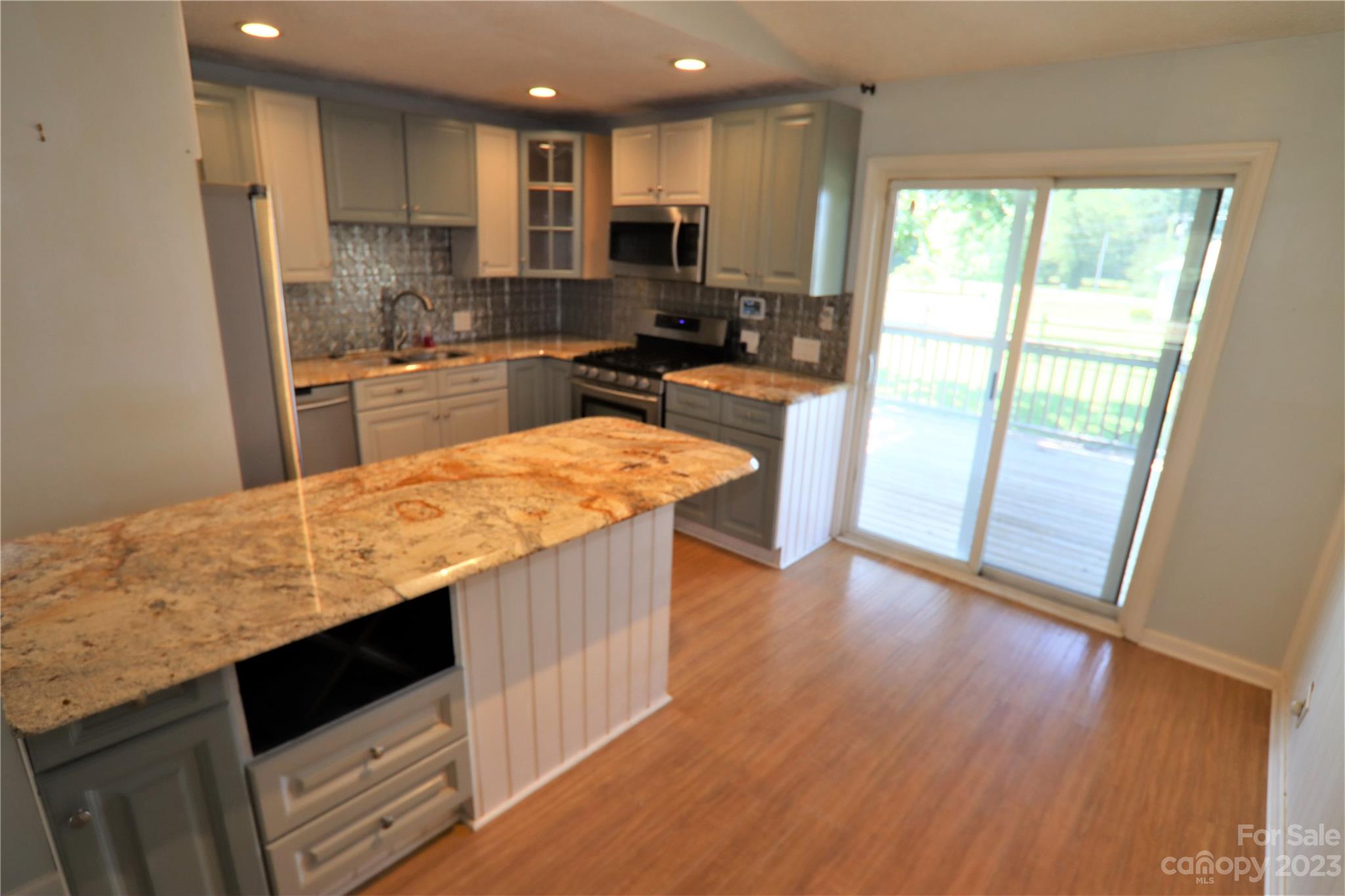12725 Mooresville Road Mount Ulla, NC 28125 - Photo 11 of 23 a large kitchen with kitchen island a large counter top space a sink a stove and a refrigerator