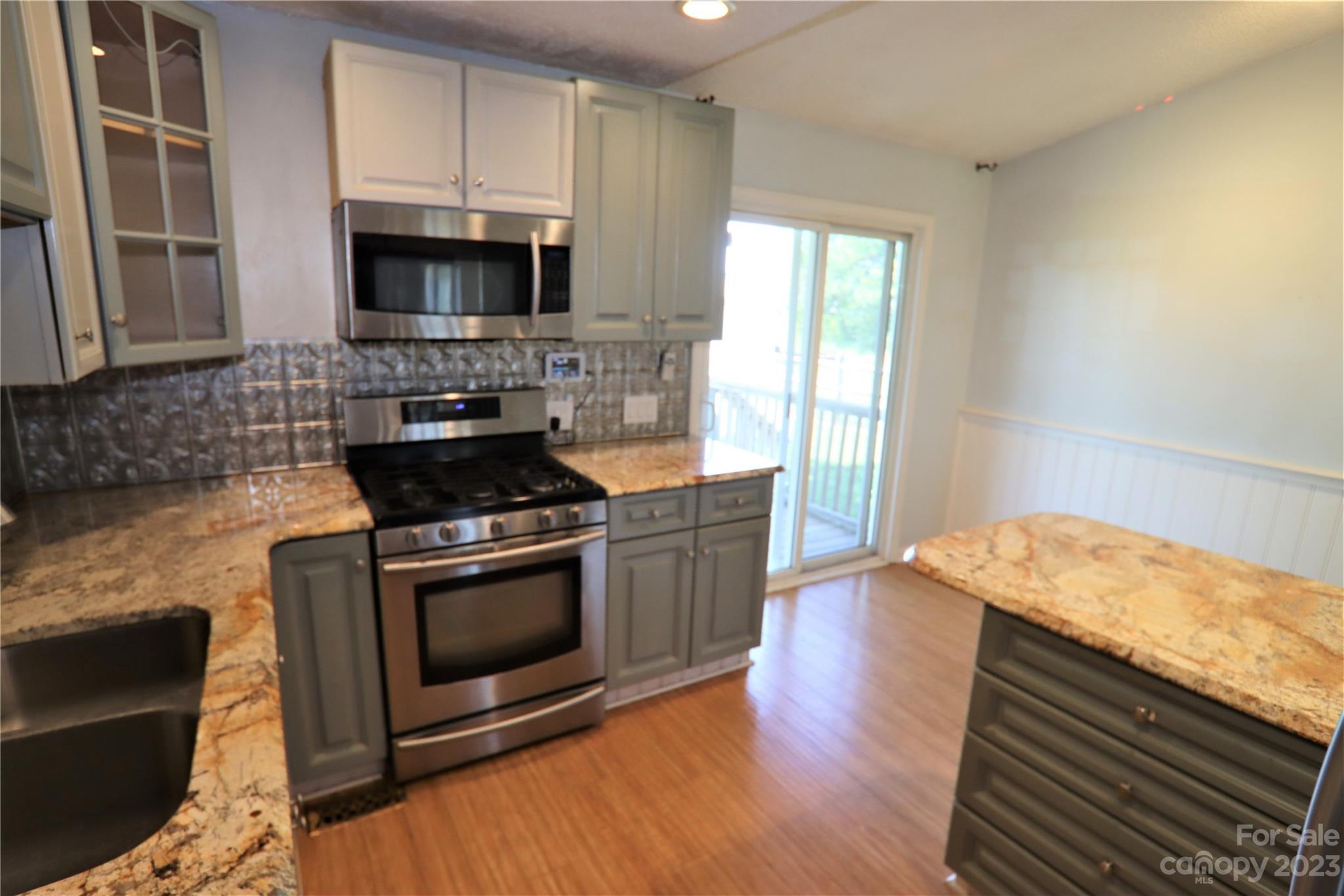 12725 Mooresville Road Mount Ulla, NC 28125 - Photo 13 of 23 a kitchen with granite countertop a stove and a microwave