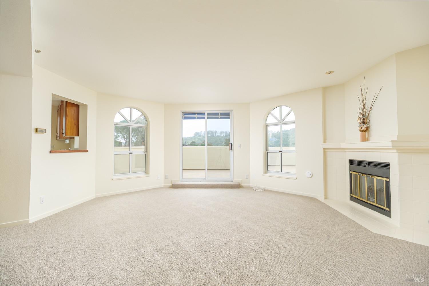 a view of an empty room with a fireplace and a window