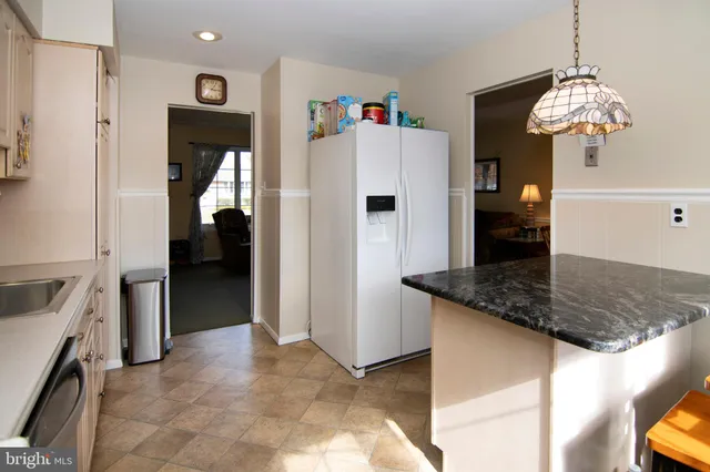 a kitchen with granite countertop a sink a stove and cabinets