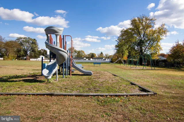 a view of a yard in front of a house with large tree