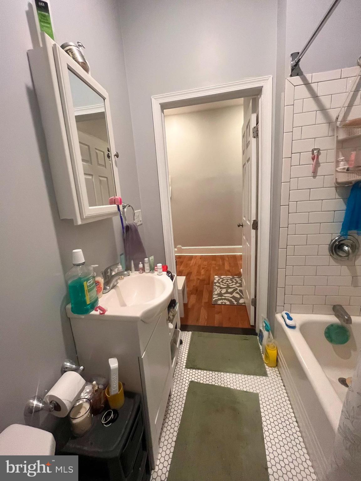 5028 Walnut Street, Unit 1F Philadelphia, PA 19139 - Photo 22 of 32 a bathroom with a tub sink and mirror