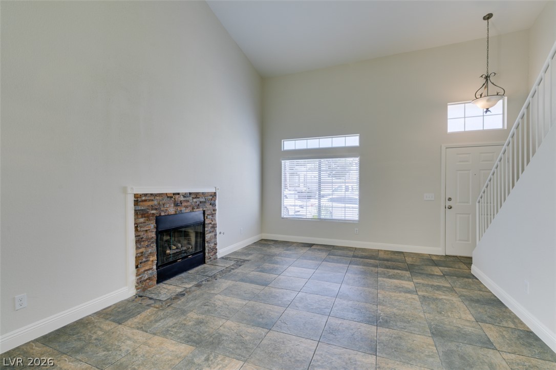 200 Luninborg Street Henderson, NV 89074 - Photo 26 of 40 A striking fireplace with a stone surround anchors this well-lit living space, featuring high ceilings.