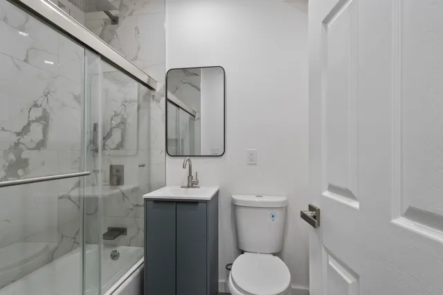 a bathroom with a toilet sink and mirror