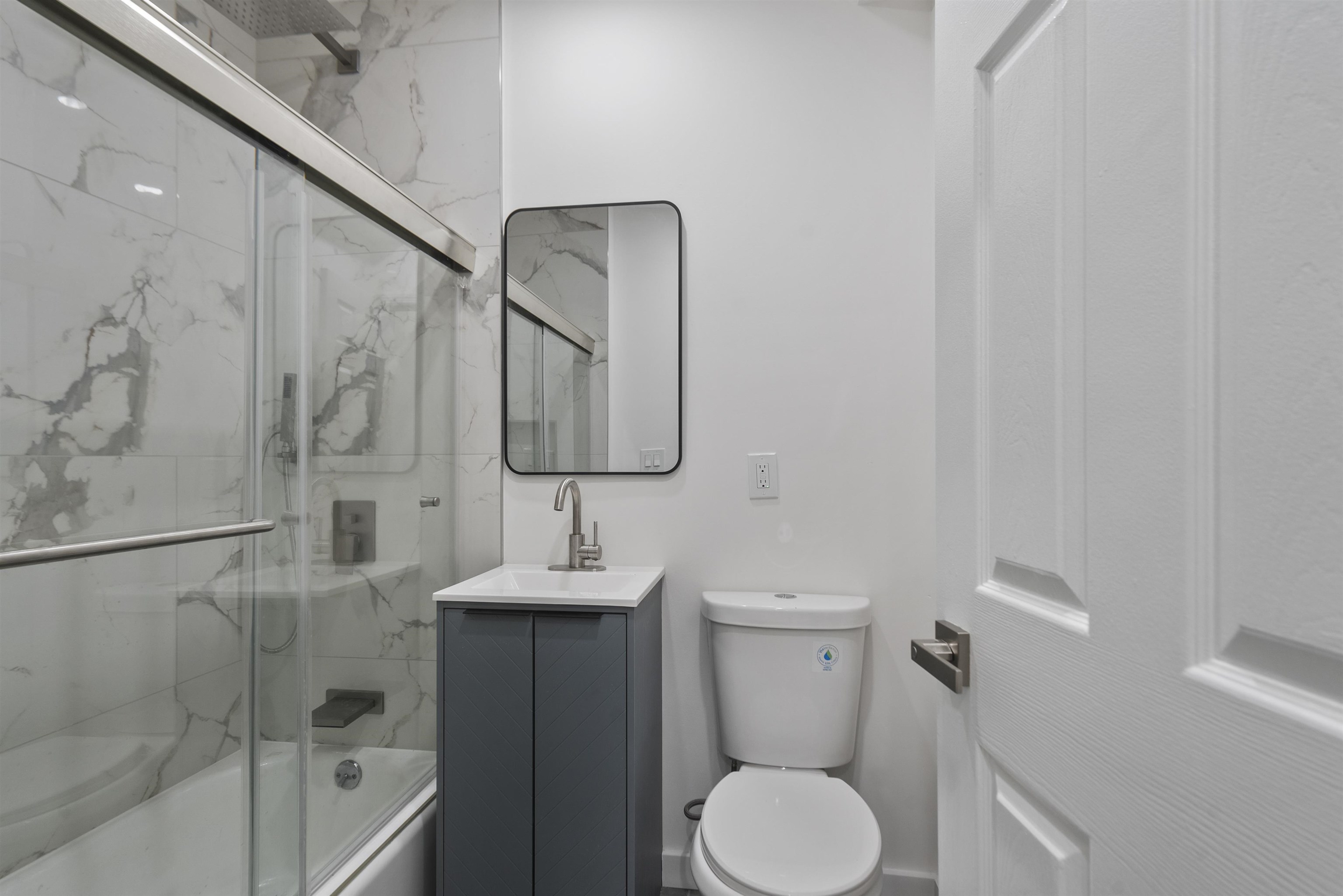 419 5th Street, Unit A Hoboken, NJ 07030 - Photo 11 of 16 a bathroom with a toilet sink and mirror