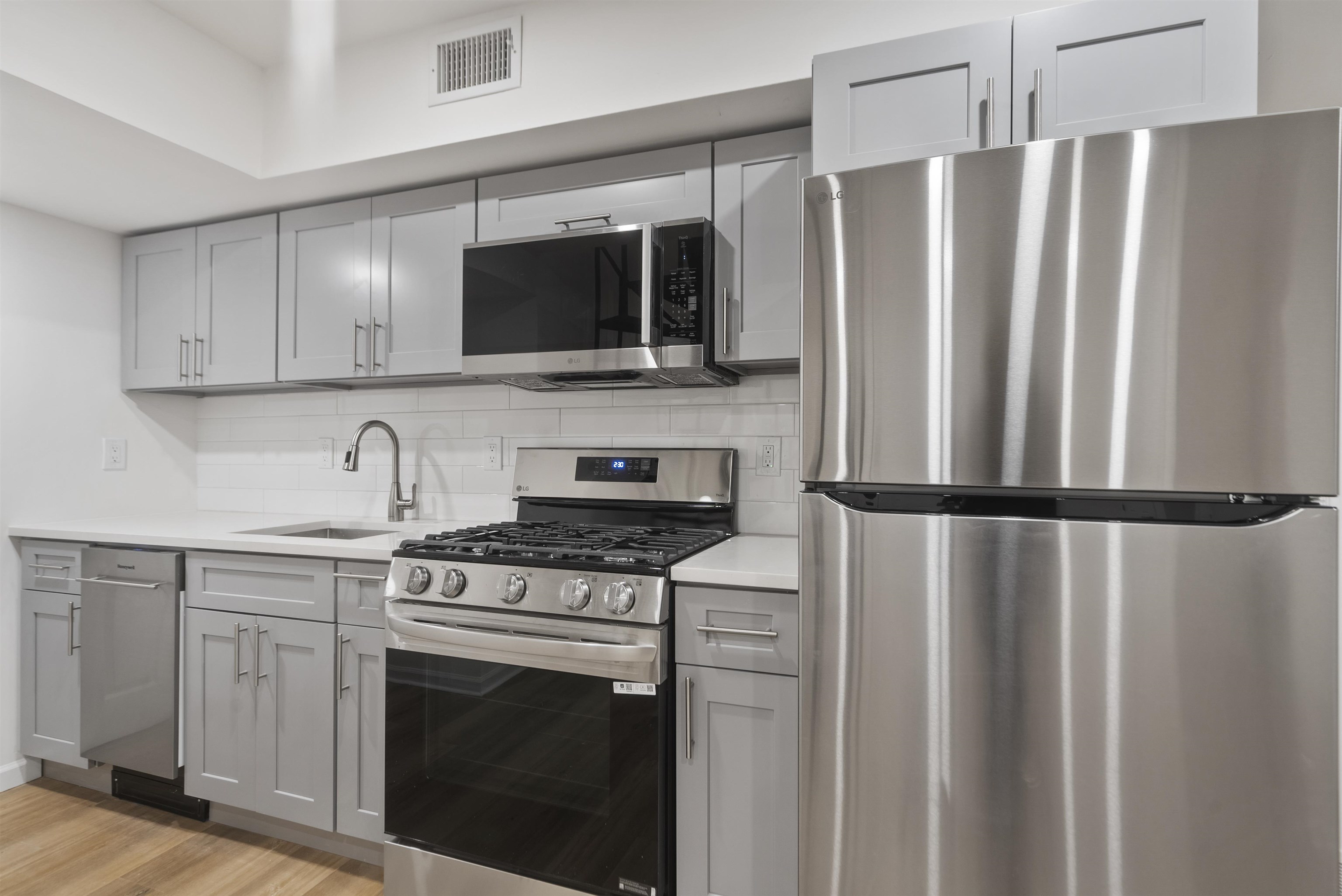 419 5th Street, Unit A Hoboken, NJ 07030 - Photo 2 of 16 a kitchen with stainless steel appliances a refrigerator stove and microwave