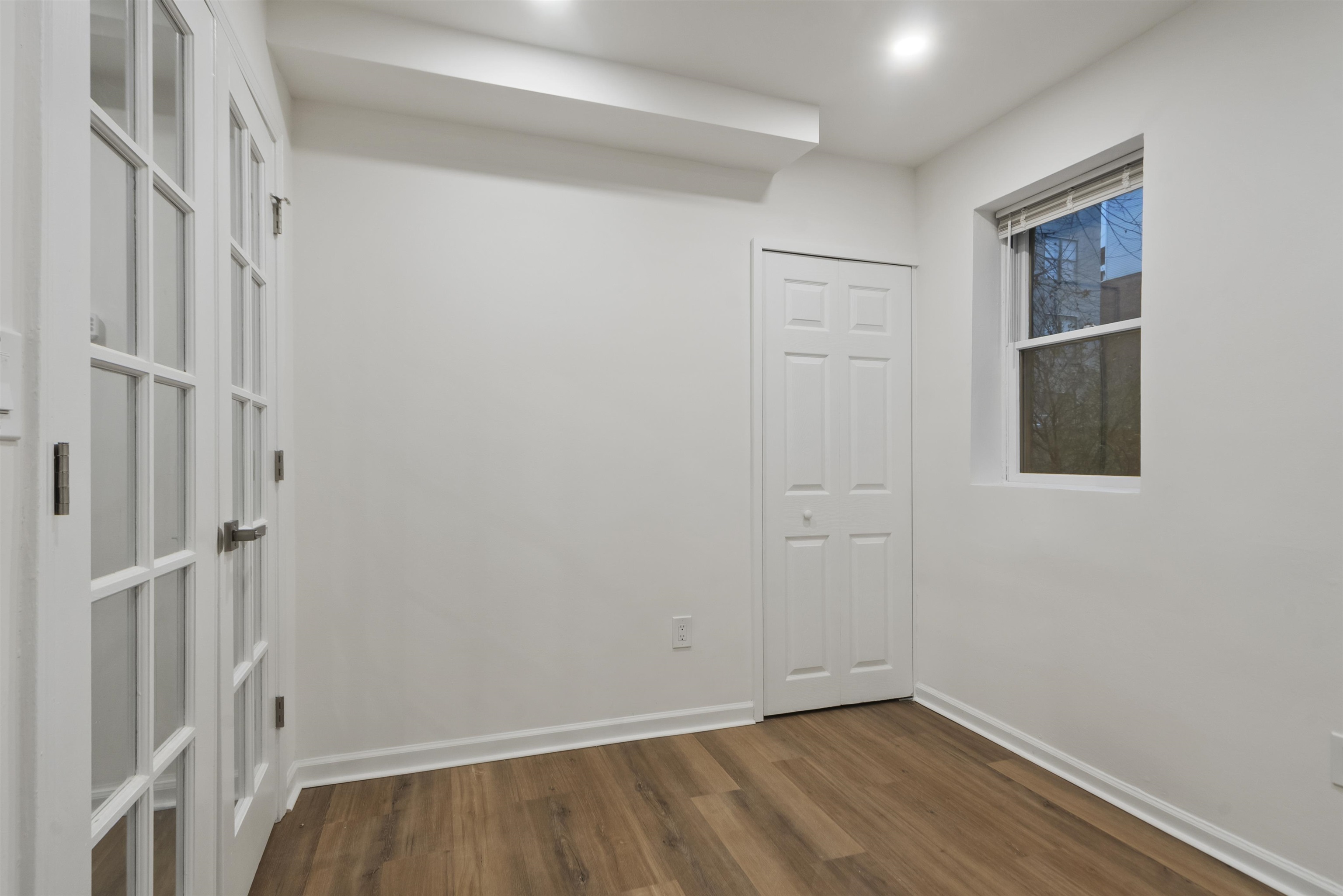 419 5th Street, Unit A Hoboken, NJ 07030 - Photo 6 of 16 a view of an empty room with wooden floor and a window