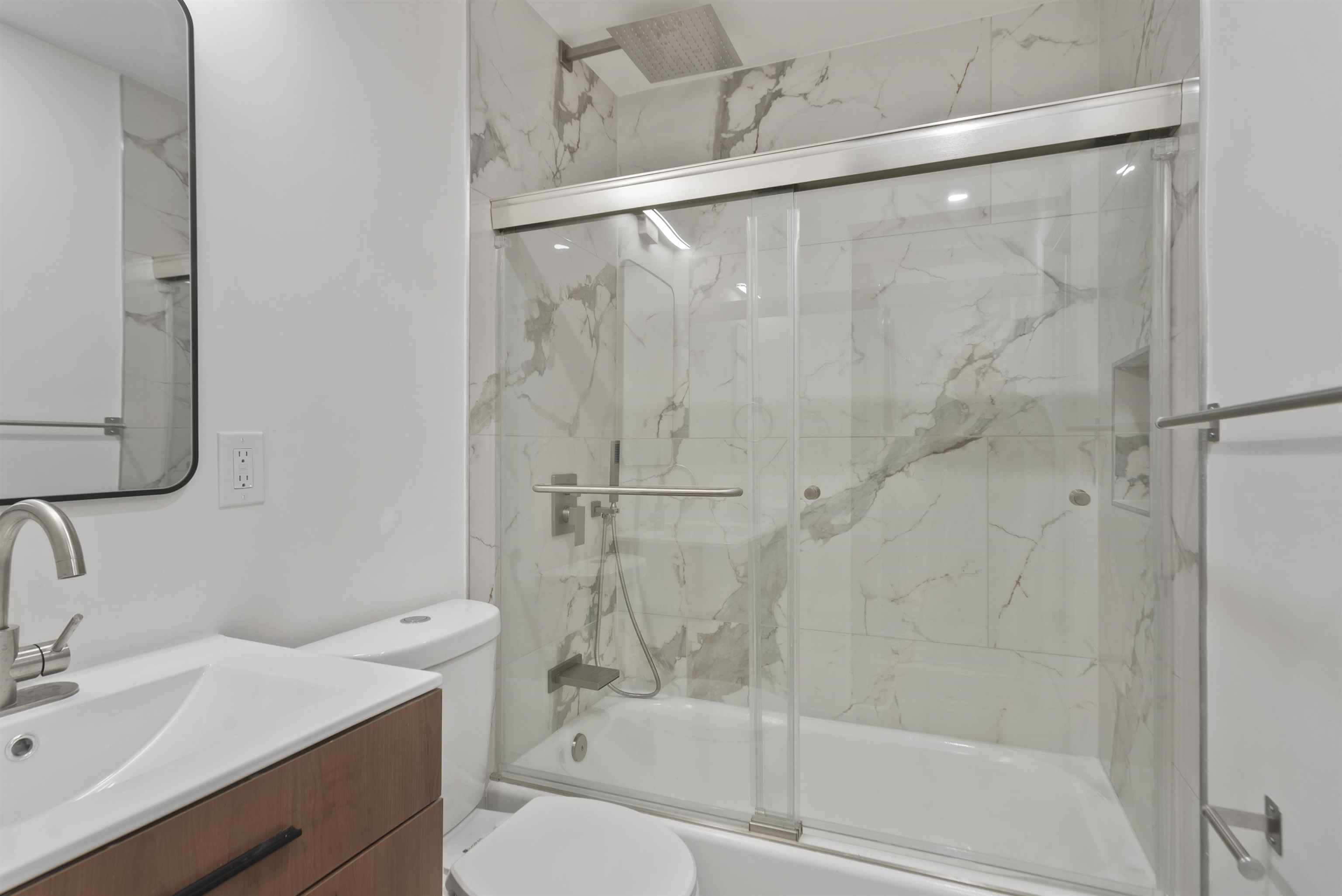 419 5th Street, Unit A Hoboken, NJ 07030 - Photo 8 of 16 a bathroom with a granite countertop bathtub shower sink vanity and toilet