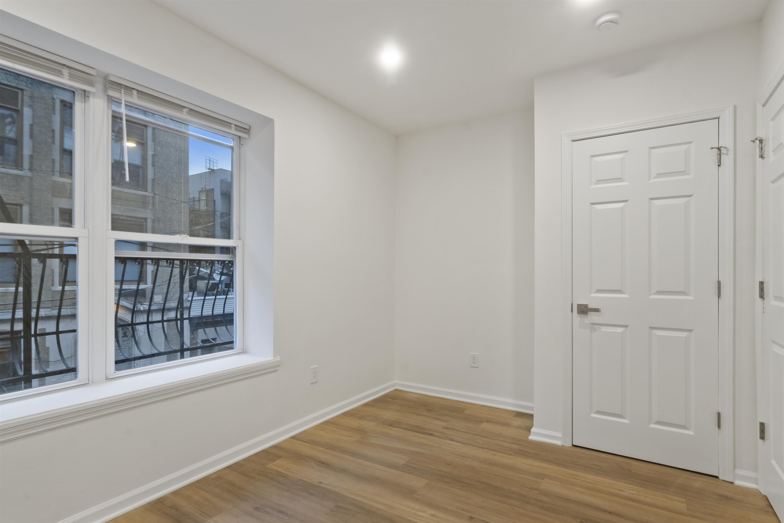 419 5th Street, Unit A Hoboken, NJ 07030 - Photo 10 of 16 an empty room with wooden floor and windows