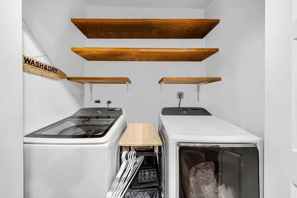 a backyard of a house with table and chairs under an umbrella