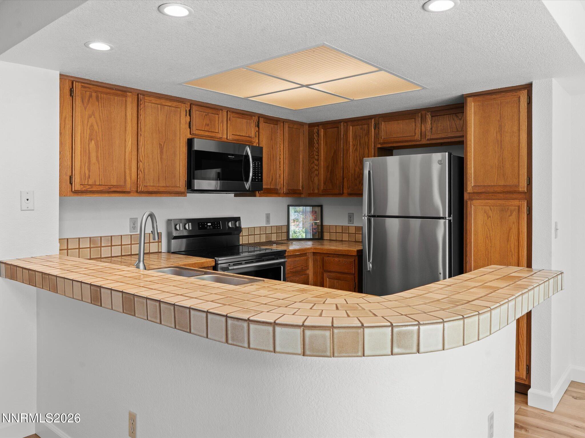 3170 Oakshire Court Reno, NV 89509 - Photo 21 of 43 a kitchen with stainless steel appliances granite countertop a refrigerator a stove top oven a sink and dishwasher