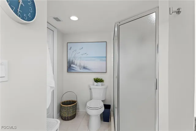 a bathroom with a toilet and a painting on the wall