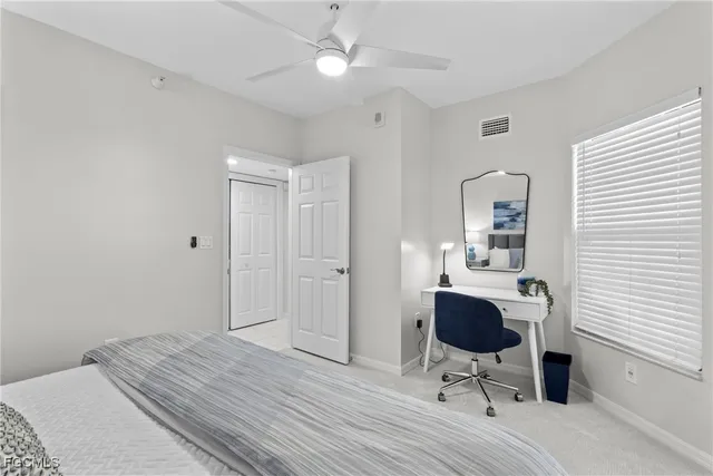 a bedroom with a bed and a chandelier fan
