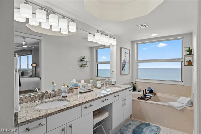 a bathroom with a granite countertop sink a large mirror and a bathtub