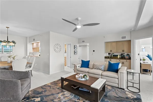 a living room with furniture and view of kitchen