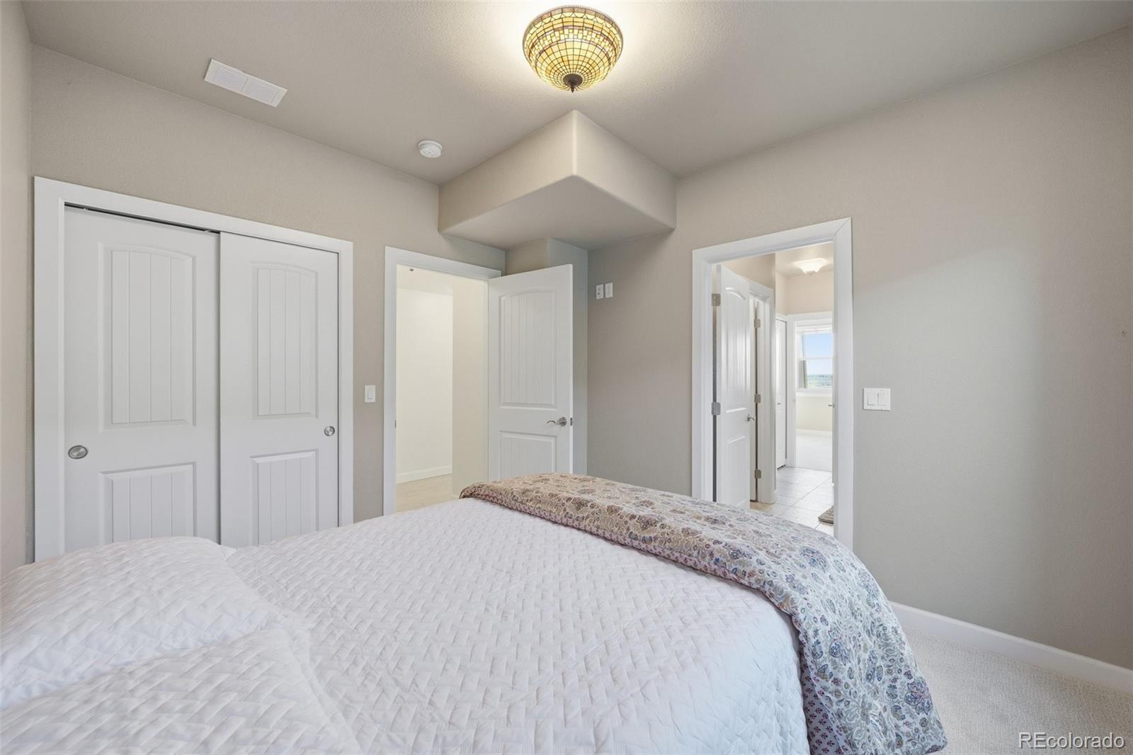 7600 Patrick Trail Elizabeth, CO 80107 - Photo 47 of 50 a bedroom with a bed and a chandelier