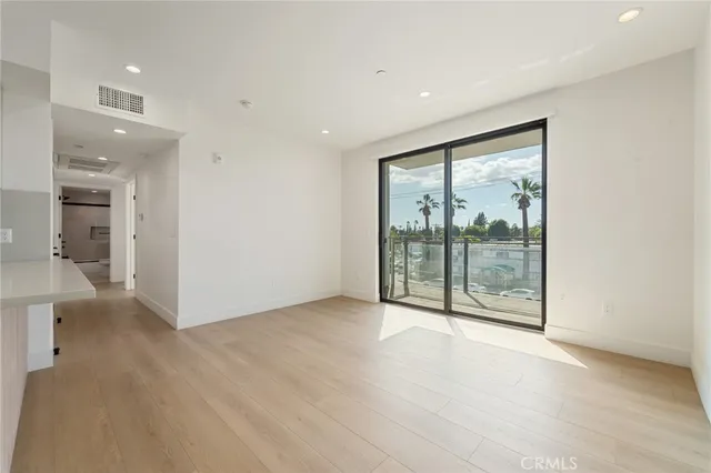 a view of an empty room with glass door and a window