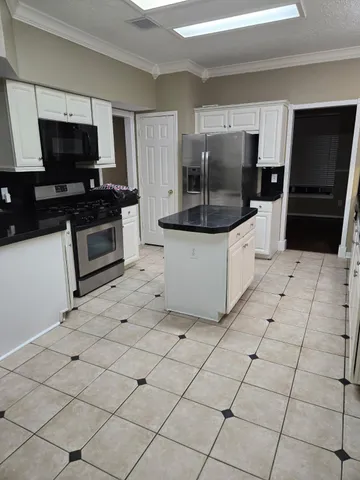 a kitchen with stainless steel appliances a refrigerator a stove a microwave and cabinets