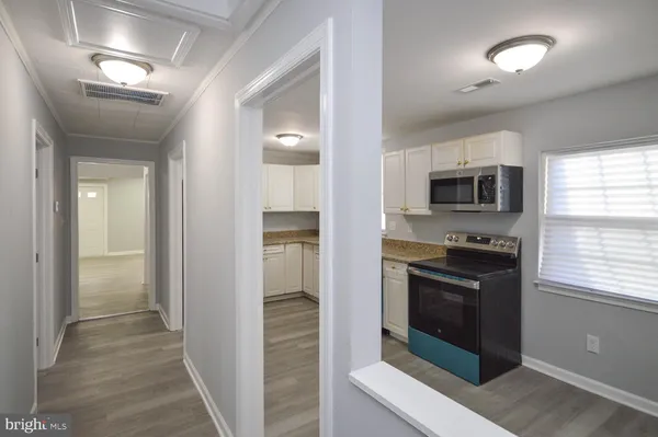 a view of a kitchen with a stove a refrigerator a microwave and a sink