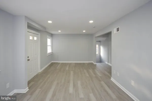 a view of empty room with wooden floor