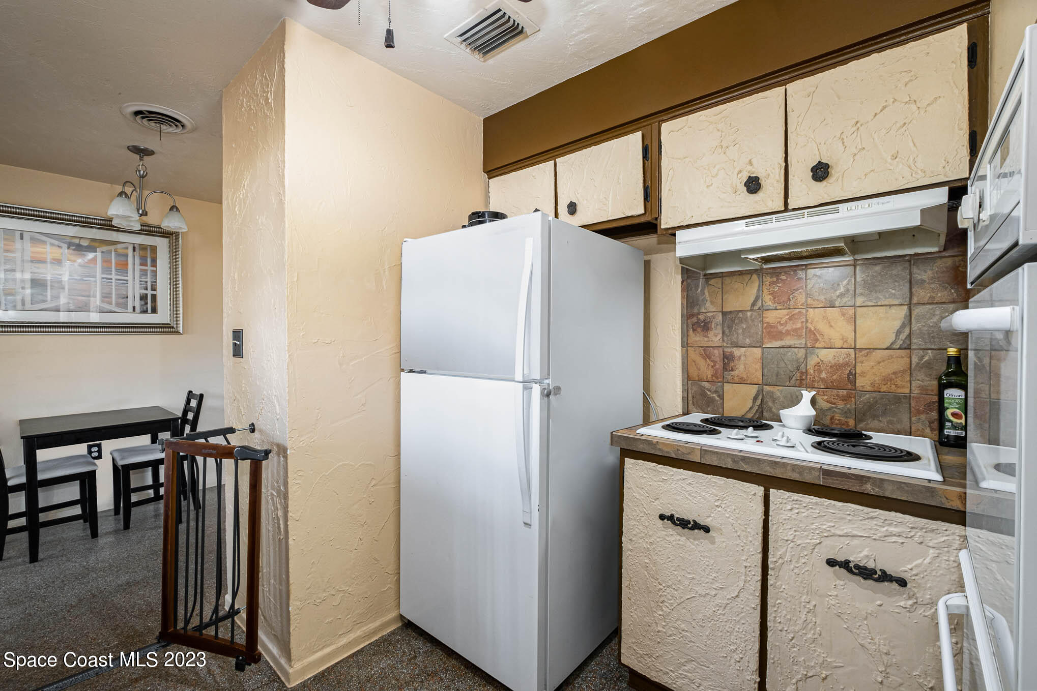 2710 Locksley Road Melbourne, FL 32935 - Photo 12 of 25 a kitchen with stainless steel appliances a refrigerator and cabinets