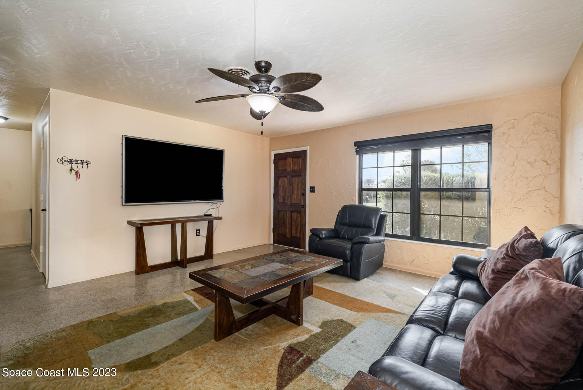 2710 Locksley Road Melbourne, FL 32935 - Photo 7 of 25 a living room with furniture and a flat screen tv