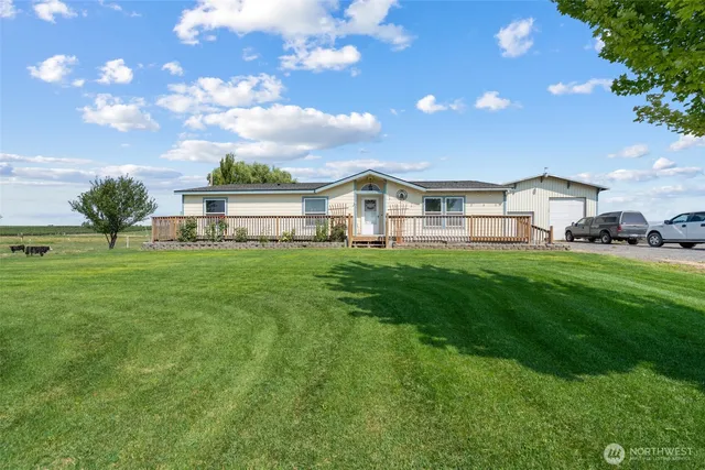 a view of a house with a big yard and large trees