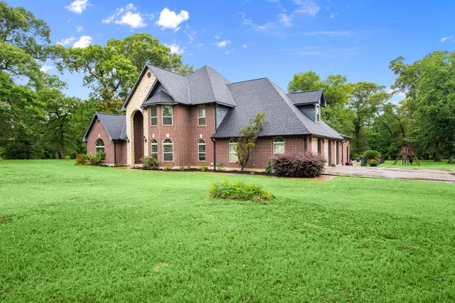 a aerial view of a house with yard and green space