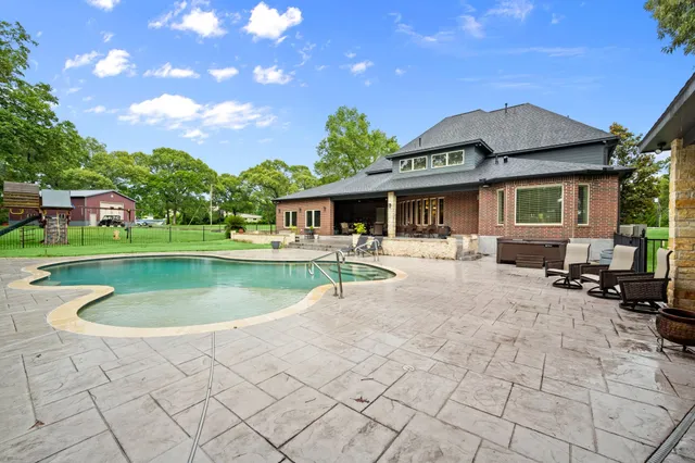 a view of a house with a swimming pool and a yard