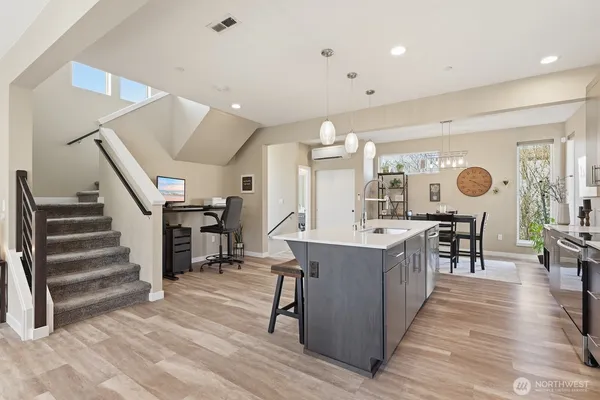 a kitchen with stainless steel appliances kitchen island hardwood floor and a sink