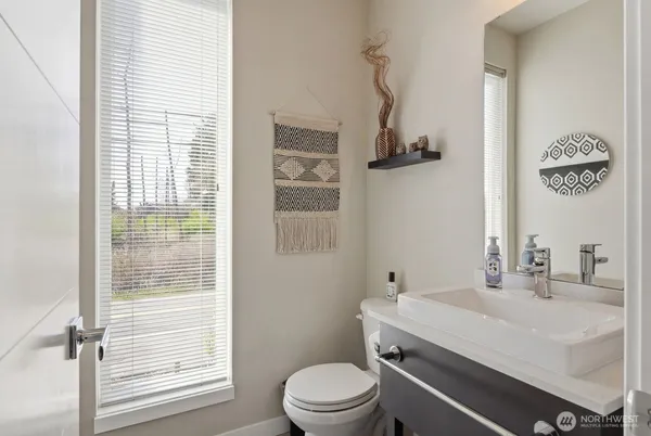 a bathroom with a sink a toilet and a window