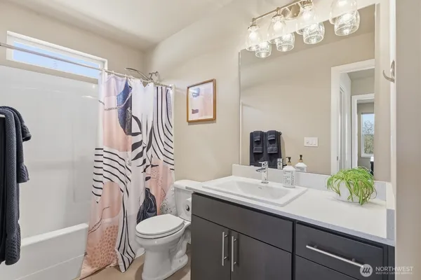 a bathroom with a sink a toilet a mirror a vanity and shower