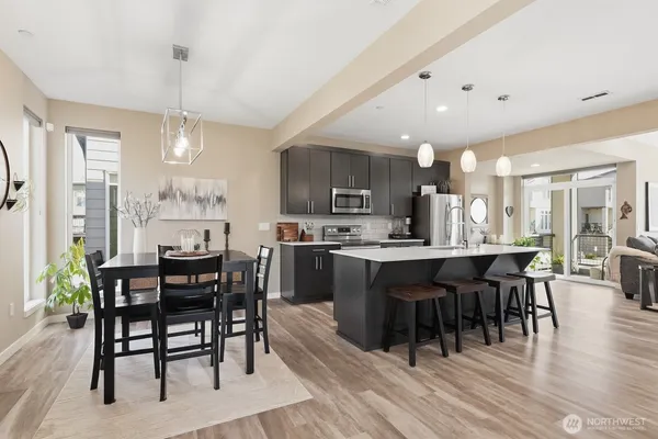 a large kitchen with kitchen island a dining table and chairs