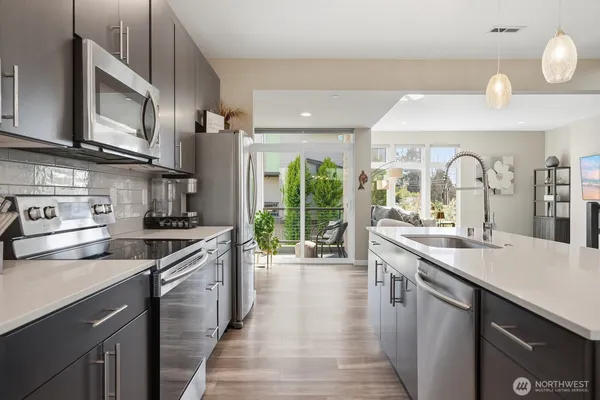 a kitchen with stainless steel appliances granite countertop a stove a sink and a microwave