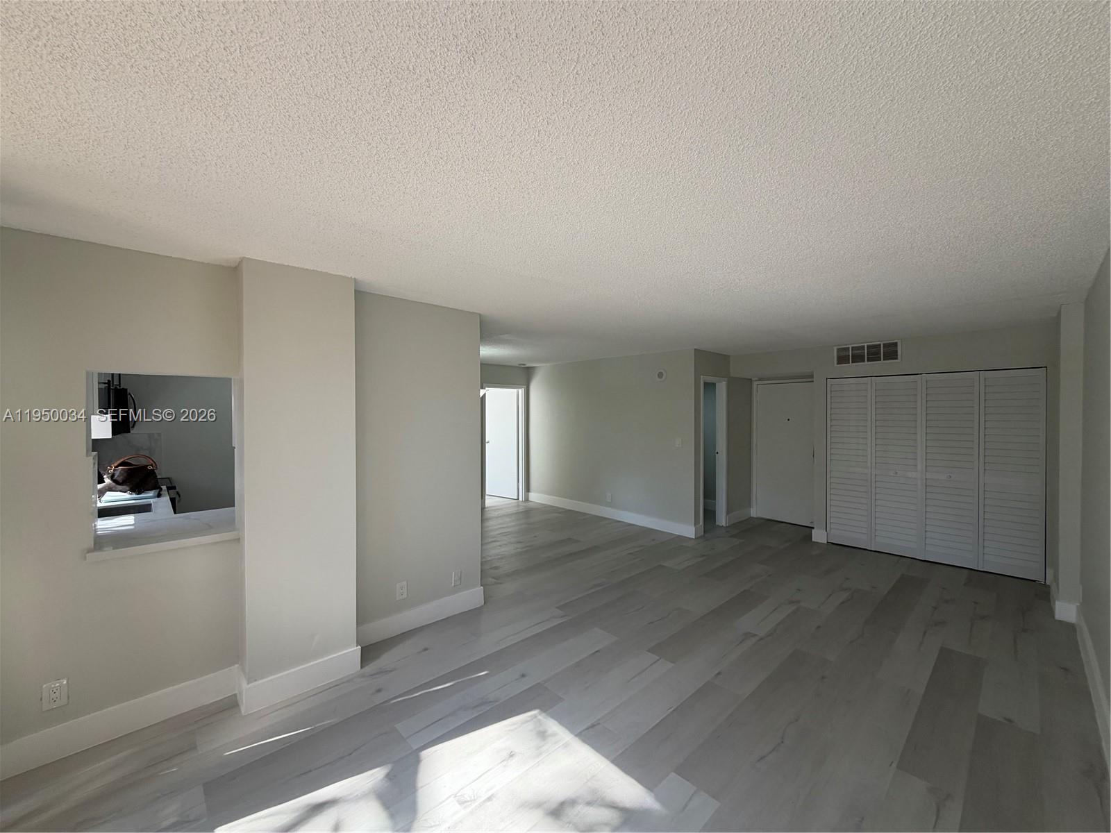 17021 North Bay Road, Unit 216 Sunny Isles Beach, FL 33160 - Photo 11 of 40 an empty room with wooden floor and closet