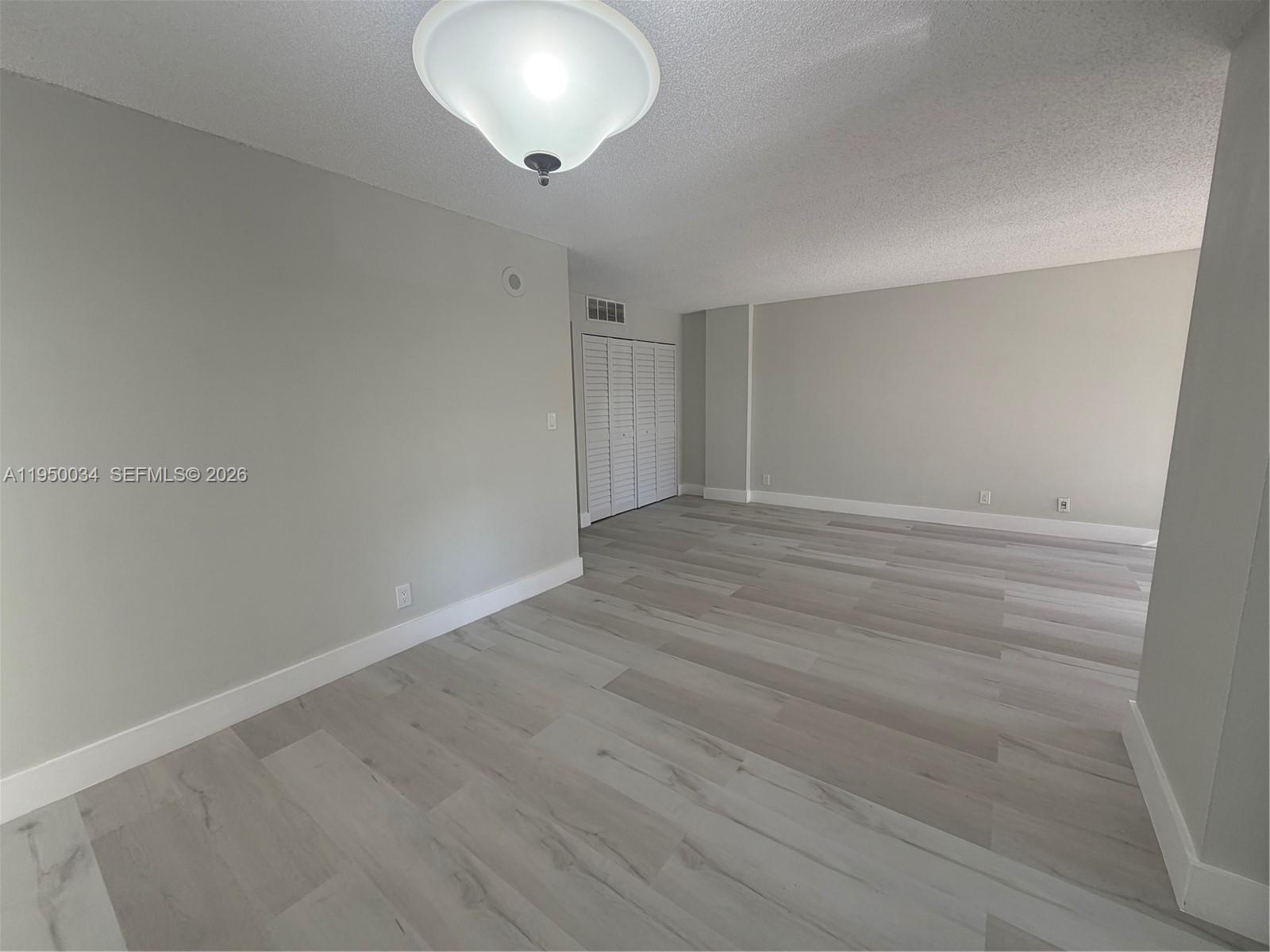 17021 North Bay Road, Unit 216 Sunny Isles Beach, FL 33160 - Photo 16 of 40 an empty room with wooden floor and windows