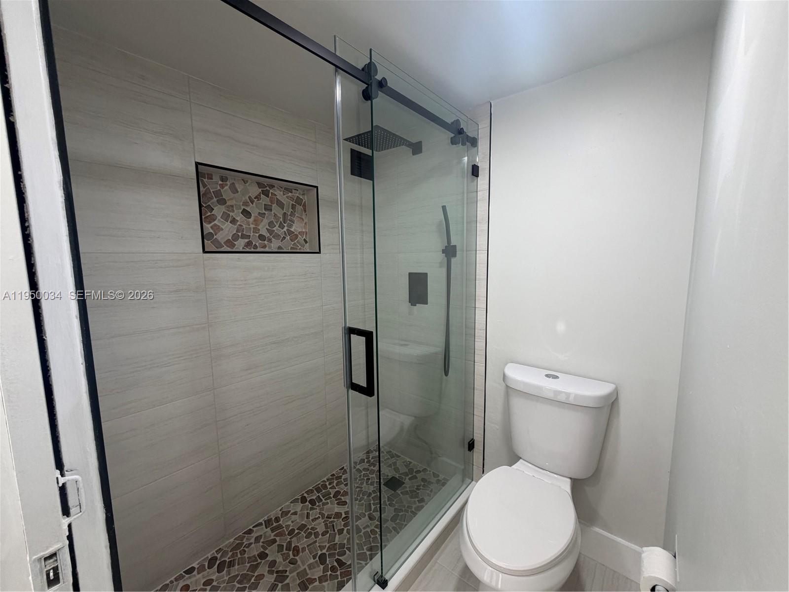17021 North Bay Road, Unit 216 Sunny Isles Beach, FL 33160 - Photo 20 of 40 a white toilet sitting next to a shower