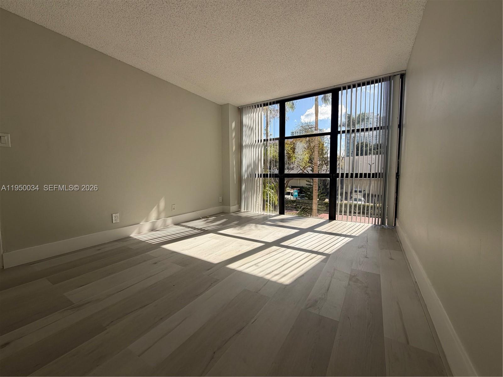 17021 North Bay Road, Unit 216 Sunny Isles Beach, FL 33160 - Photo 23 of 40 an empty room with wooden floor and windows
