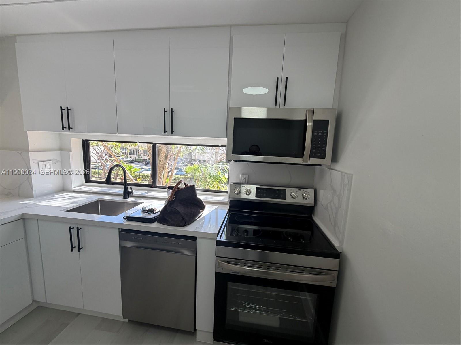 17021 North Bay Road, Unit 216 Sunny Isles Beach, FL 33160 - Photo 5 of 40 a kitchen with a sink and a stove top oven