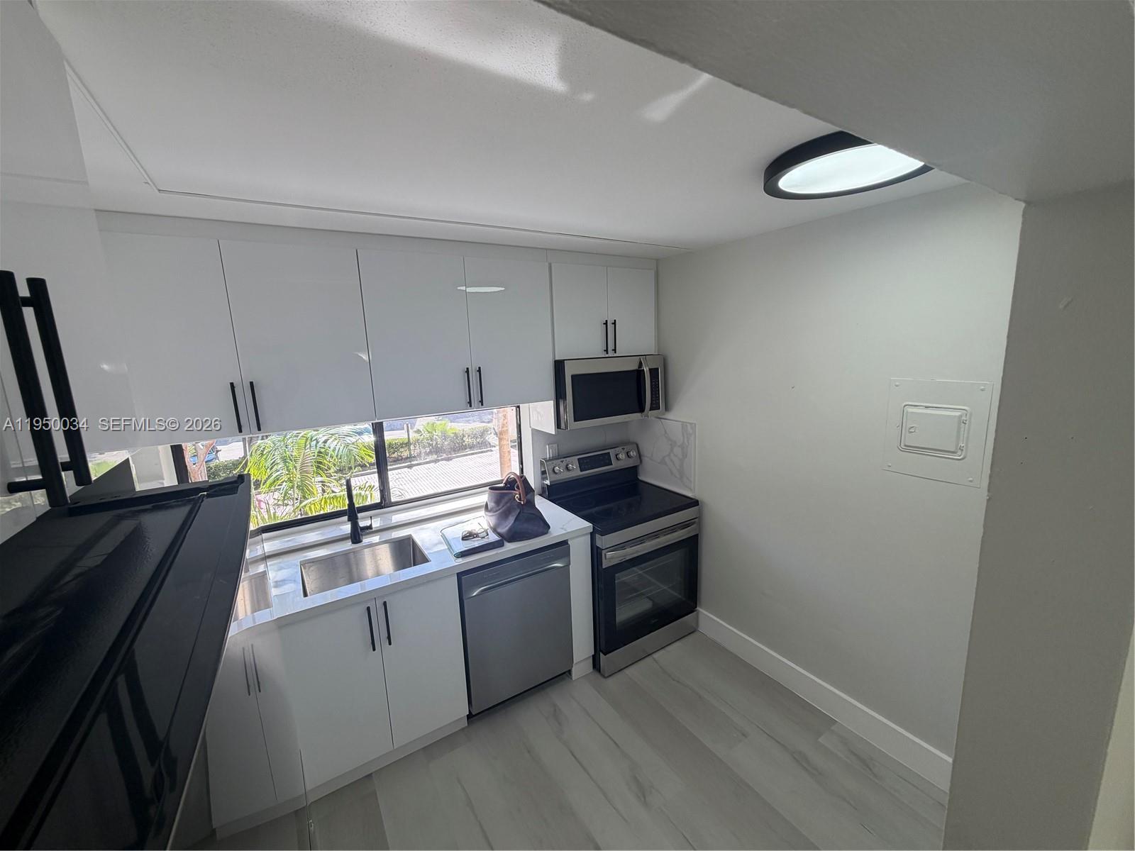 17021 North Bay Road, Unit 216 Sunny Isles Beach, FL 33160 - Photo 6 of 40 a kitchen with stainless steel appliances a stove a sink and a refrigerator