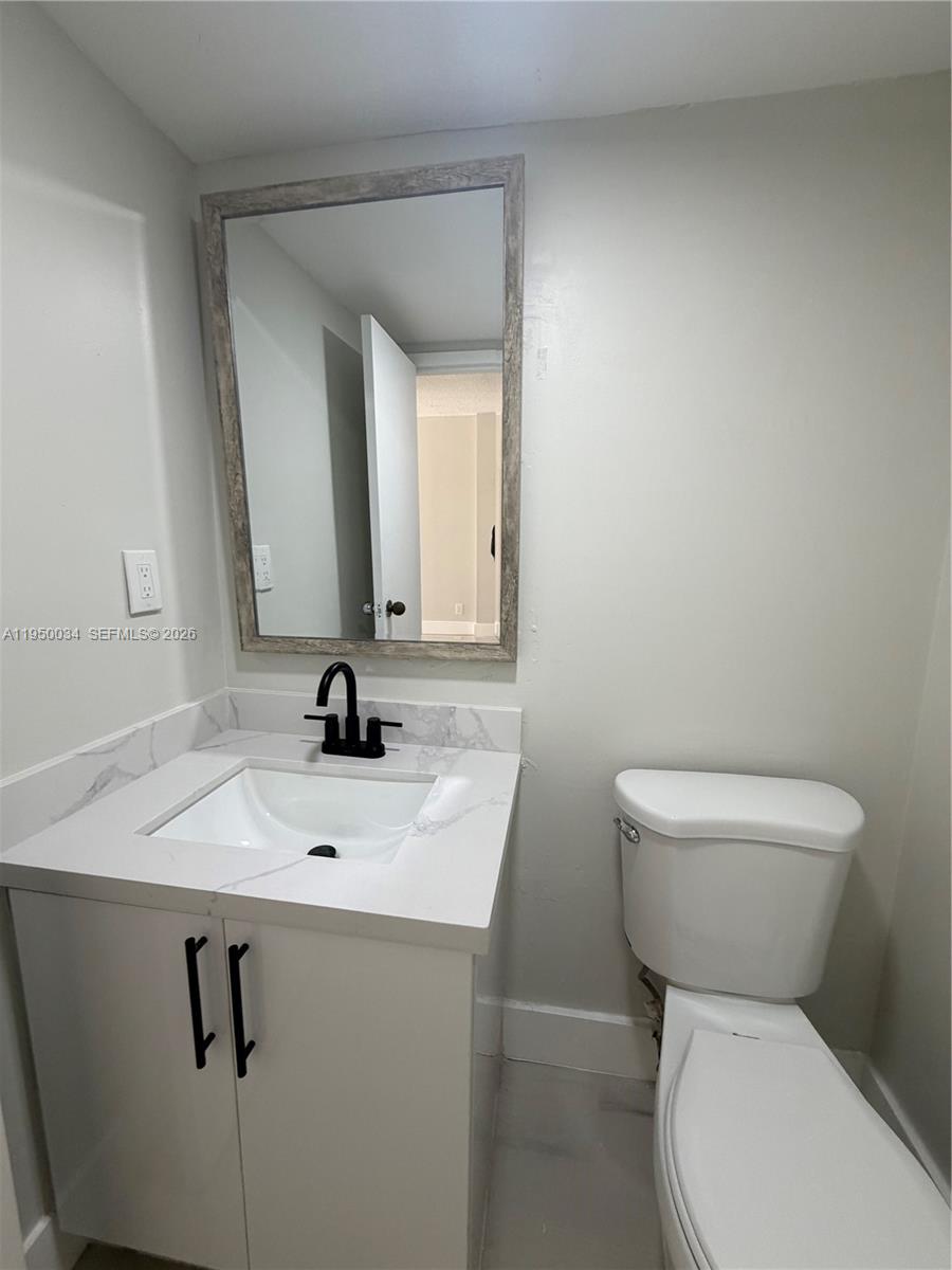 17021 North Bay Road, Unit 216 Sunny Isles Beach, FL 33160 - Photo 10 of 40 a bathroom with a toilet sink and mirror