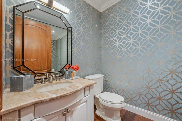 a bathroom with a granite countertop sink toilet and mirror