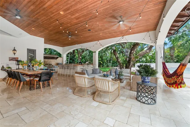 a view of a patio with table and chairs potted plants and large tree