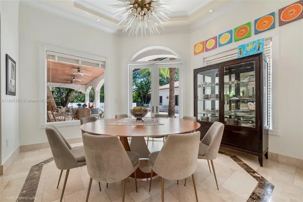 a dining room with furniture a chandelier and wooden floor