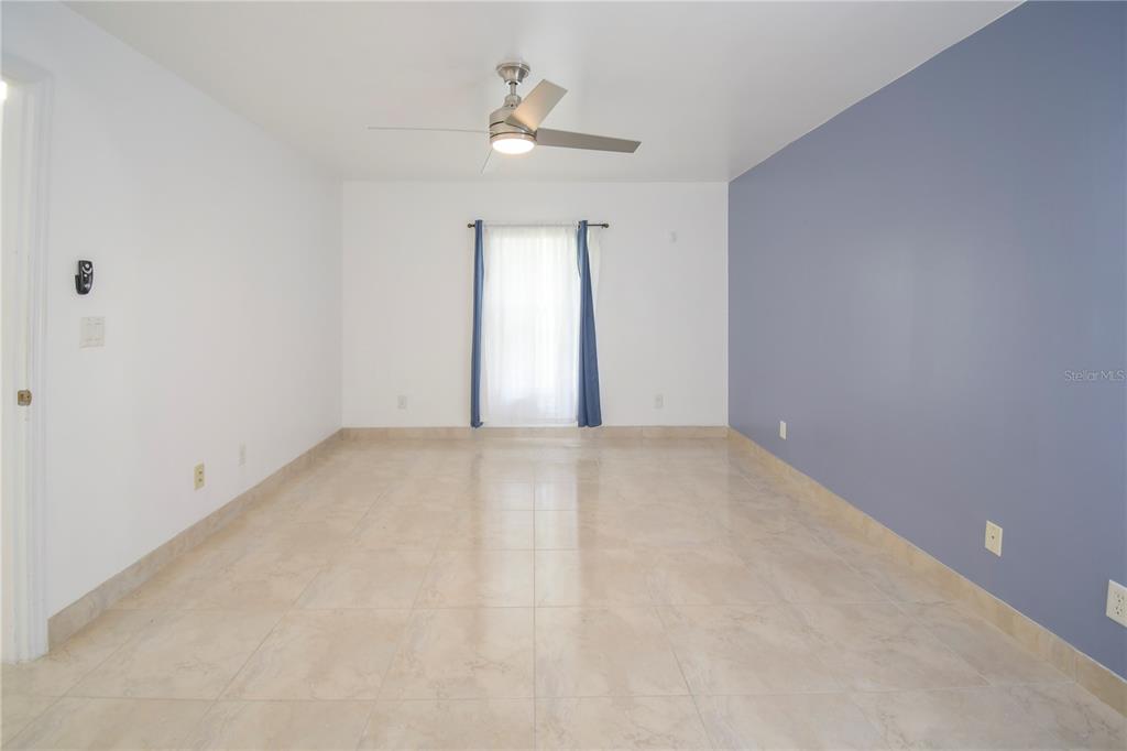 4913 Cromey Road North Port, FL 34288 - Photo 14 of 26 an empty room with a chandelier fan and windows