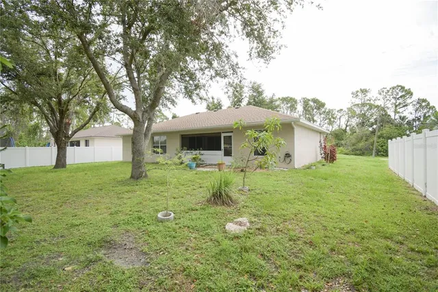a front view of a house with a garden and trees