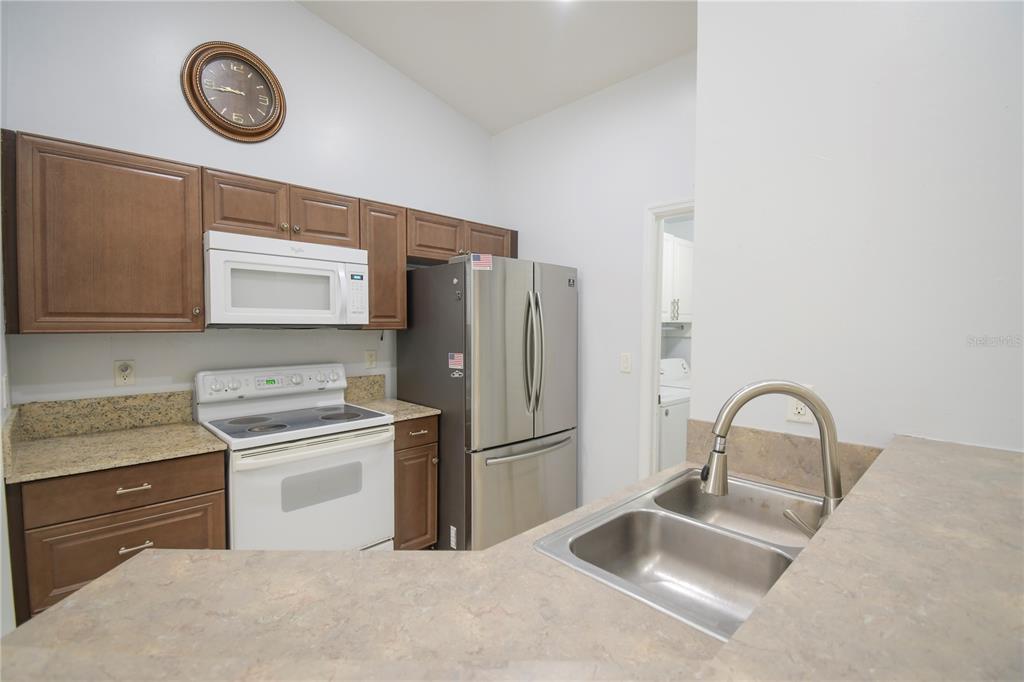 4913 Cromey Road North Port, FL 34288 - Photo 7 of 26 a kitchen with stainless steel appliances granite countertop a sink stove and refrigerator