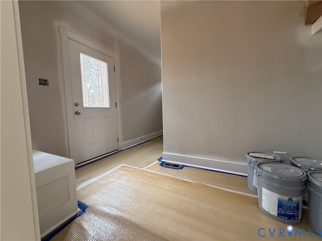 295 Merifield Drive Clarksville, VA 23927 - Photo 26 of 32 a room with a wooden floor and a table