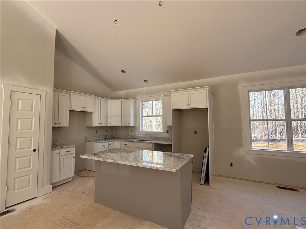 295 Merifield Drive Clarksville, VA 23927 - Photo 9 of 32 a large kitchen with kitchen island white cabinets and stainless steel appliances